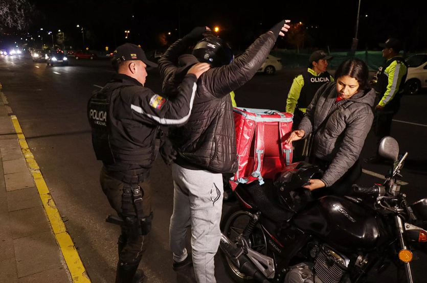 Policías ecuatorianos revisan los documentos de un motociclista en una calle antes de un apagón nacional programado en Quito, el 18 de septiembre de 2024 © Galo Paguay / AFP